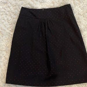 Black cotton skirt with pink dot detail.
